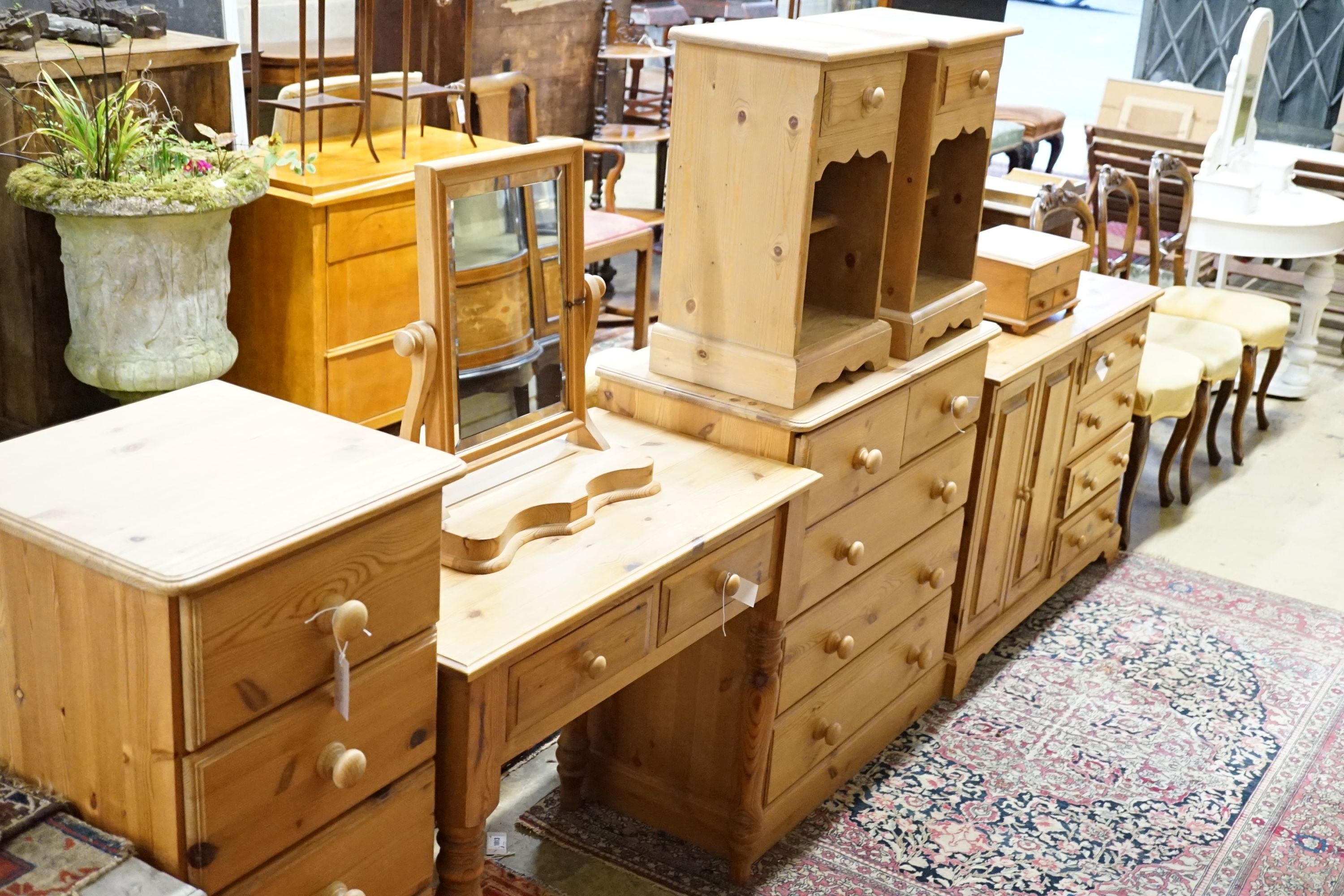 A pine side table, 89cm, a low cabinet, two chests of drawers, a pair of bedside tables, a mirror and jewellery box (8)